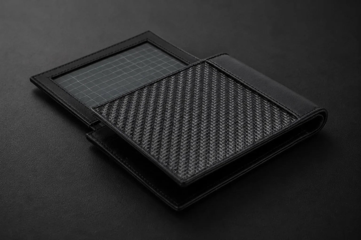 COLDFIRE wallet opened flat, showing the Dyneema ripstop lining and woven carbon fiber panel, the materials a real specification names